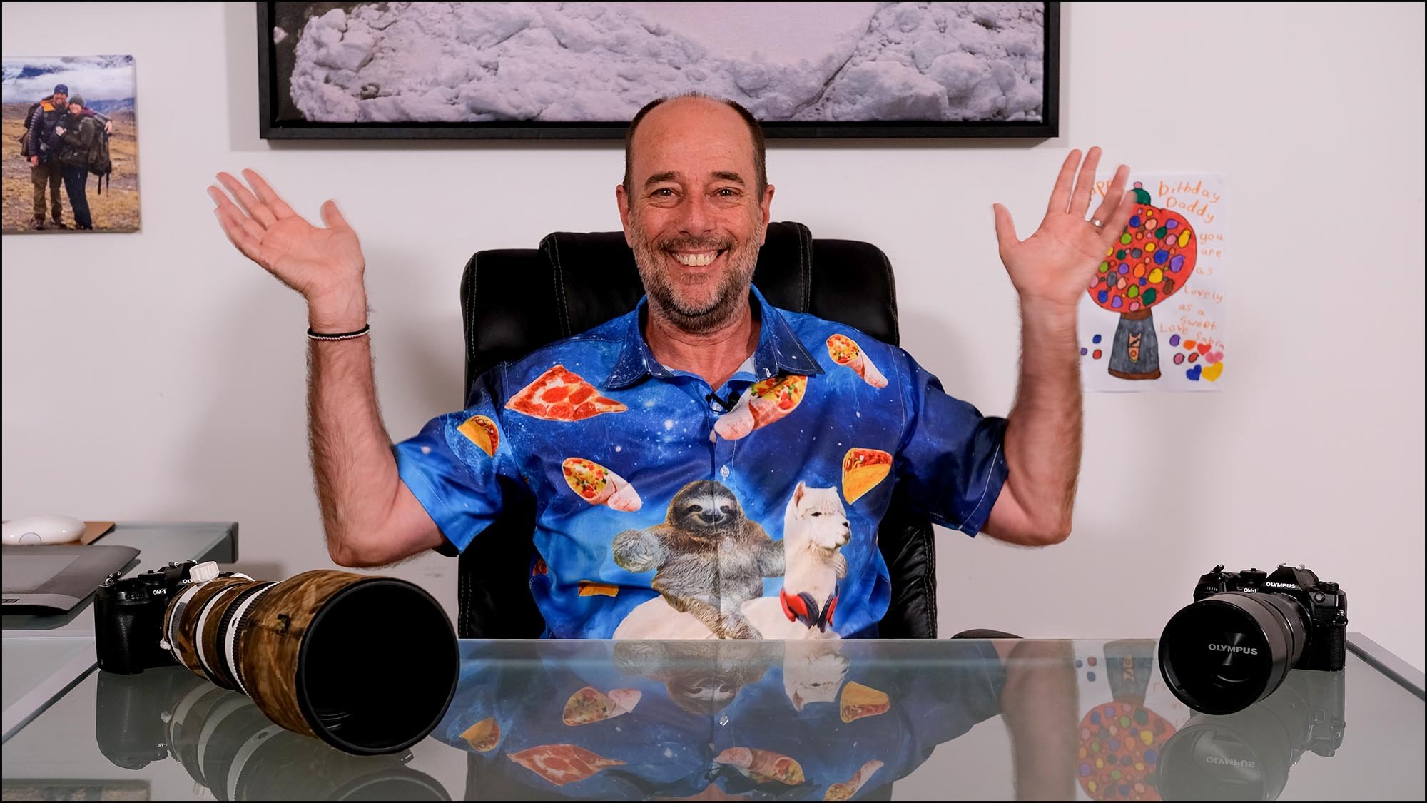 Andy Rouse waving with two cameras on a table