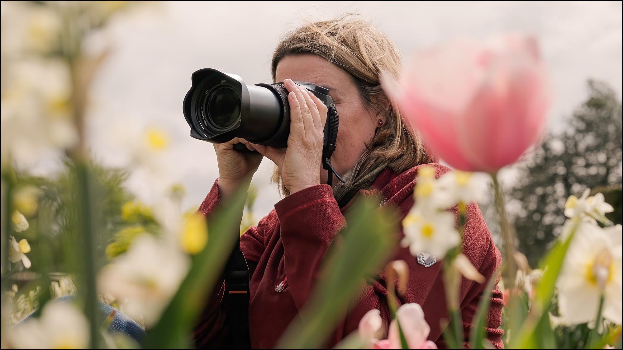 Photographer capturing tulips and spring flowers with a telephoto lens during outdoor flower photography lesson