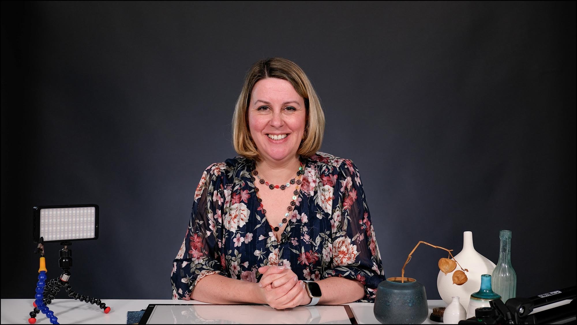 Flower photography course instructor Molly Hollman giving recap lesson with creative props on desk