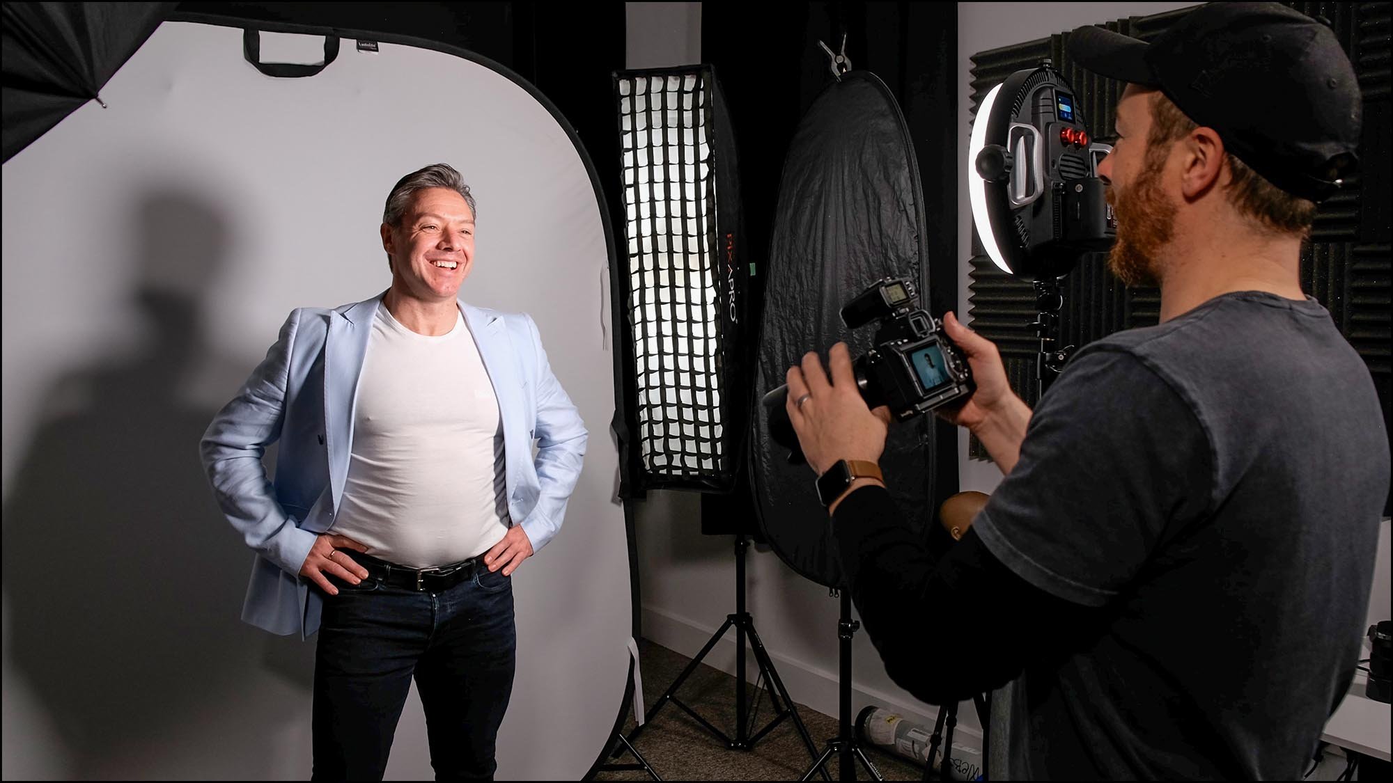 Photographer taking picture of man in studio