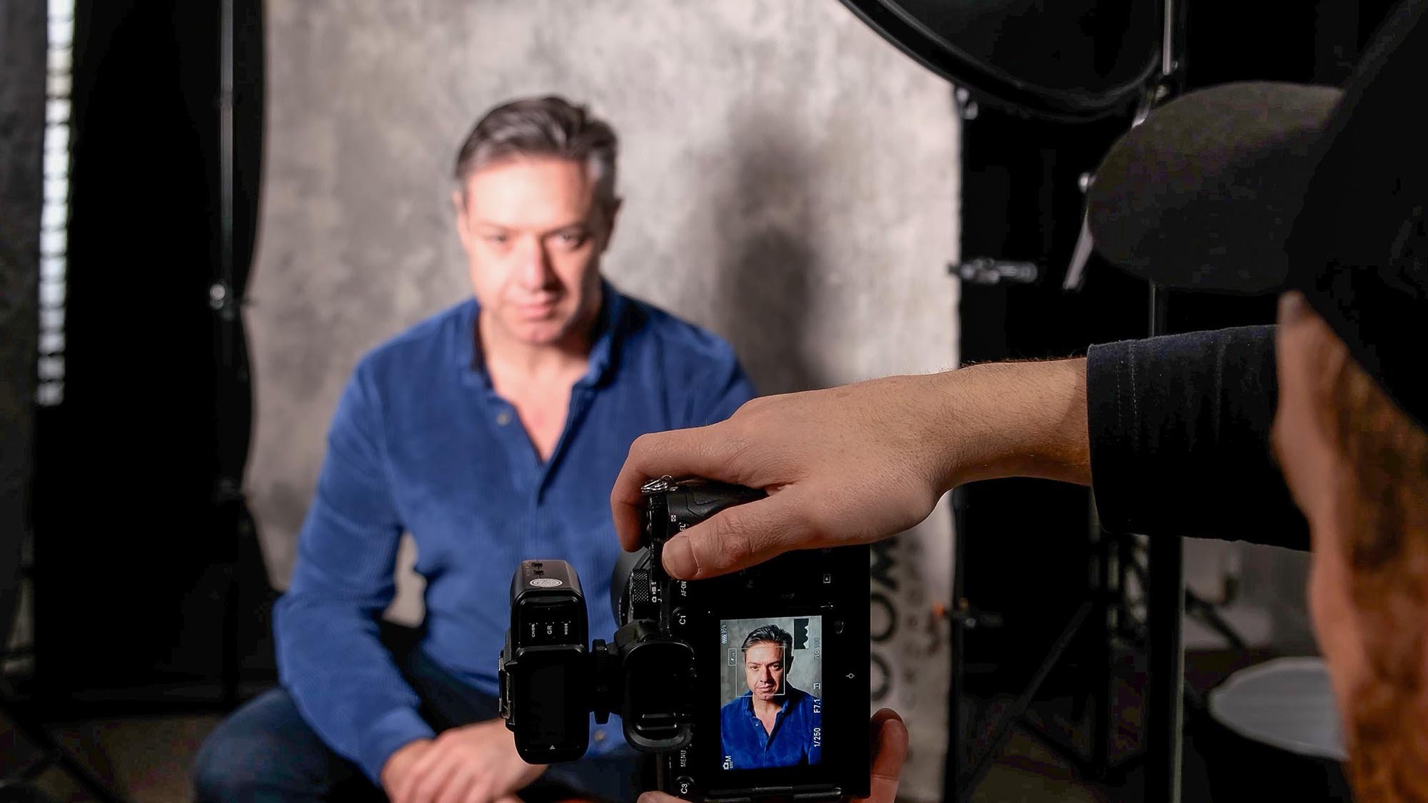 Photographer taking picture of man in studio