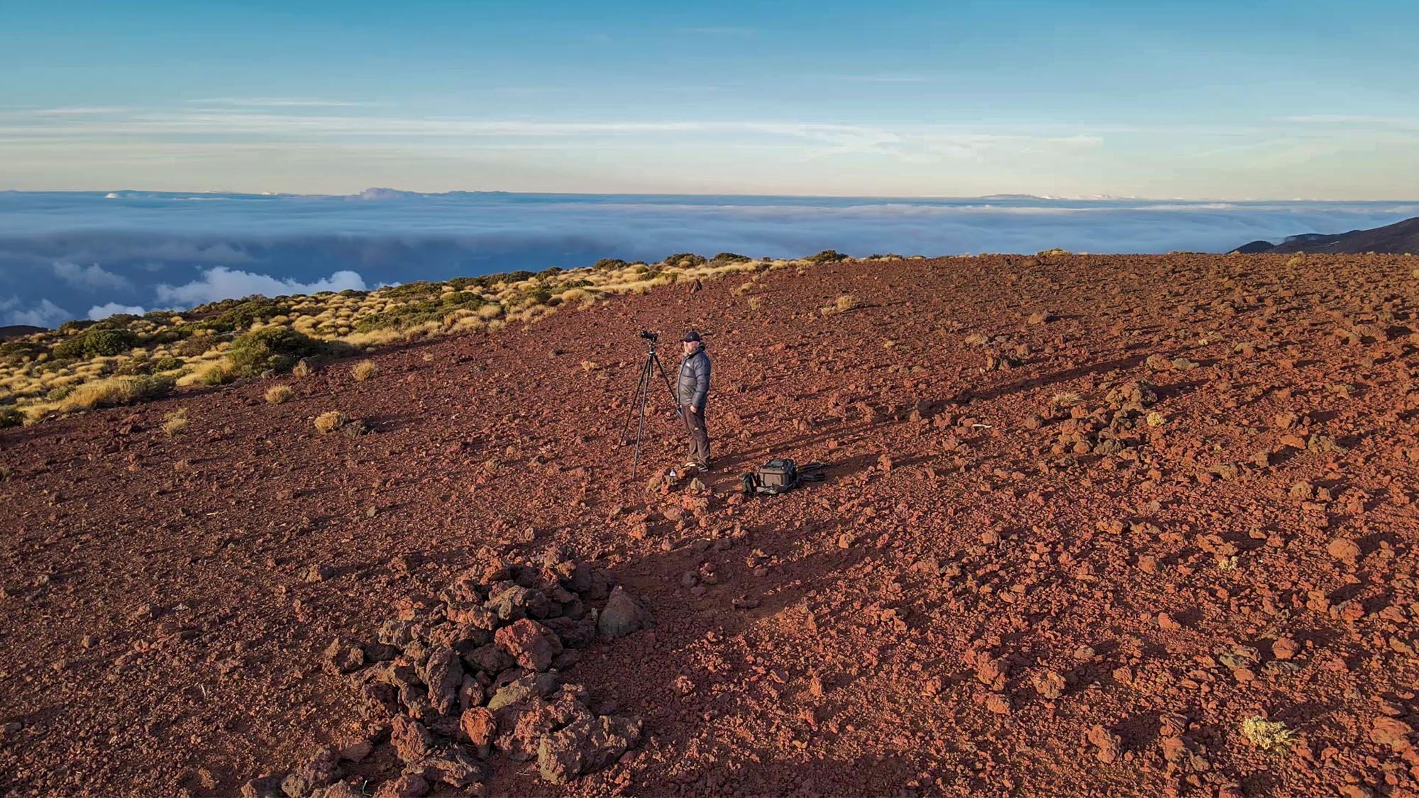 Photographer on mountain above clouds
